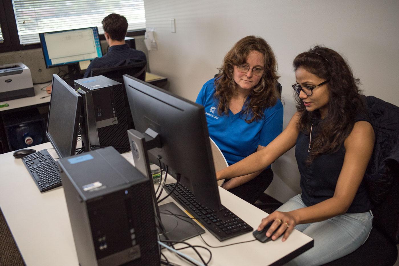 student and sjsu employee sitting at a computer
