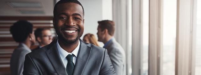 a smiling African American man dressed in a suit.