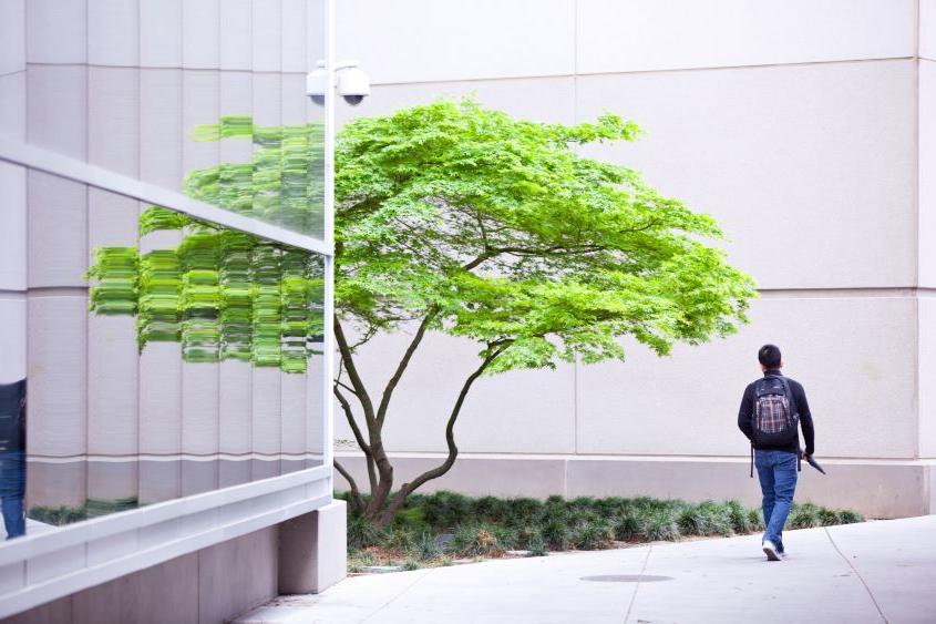 Student walking by a building.